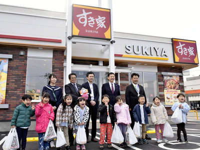 牛丼の弁当を手に双葉郡で震災後初めての外食チェーン店の開店を喜ぶ子どもたちと関係者＝浪江町