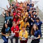 Group photo of students standing on a staircase holding small rovers