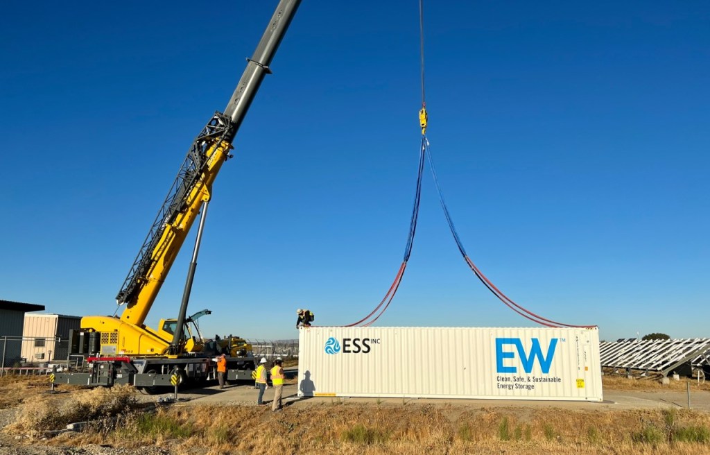 ESS Flow batteries built into a shipping container being moved with a crane.