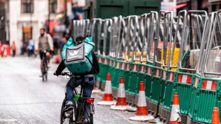 Deliveroo bicycle man delivering food by construction site