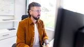 Photo of a person sitting at a computer.