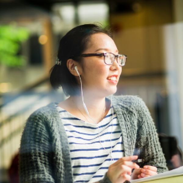 Student listening to her headphones at Starbucks