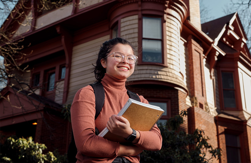 Student in front of Simon Benson House