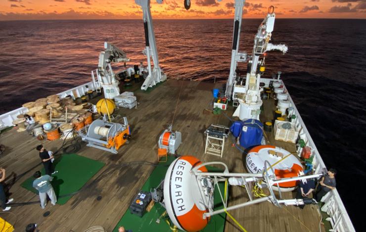 Two mooring orange and white buoy on the deck of the ship in the Indian Ocean during sunset