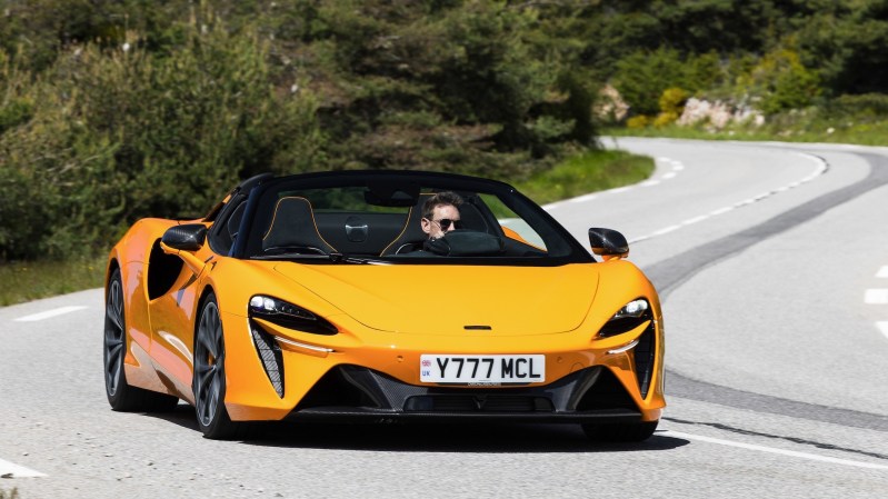 an orange convertible sports car on a rural road