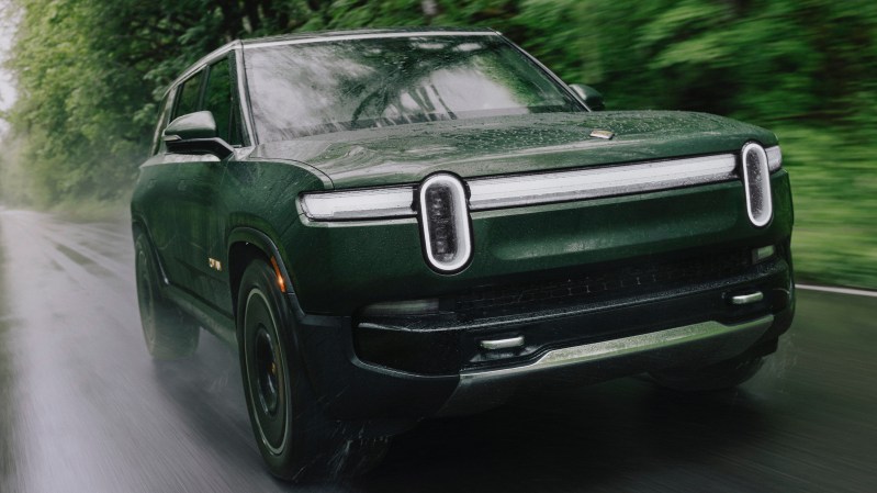 green suv driving on a road in rain day