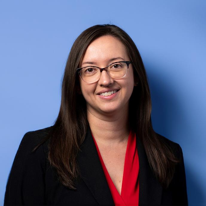 Meredith Hughes wearing a jacket in front of blue background