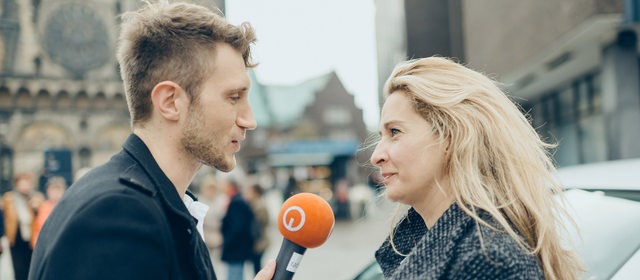 Reporter im Gespräch mit einer Frau