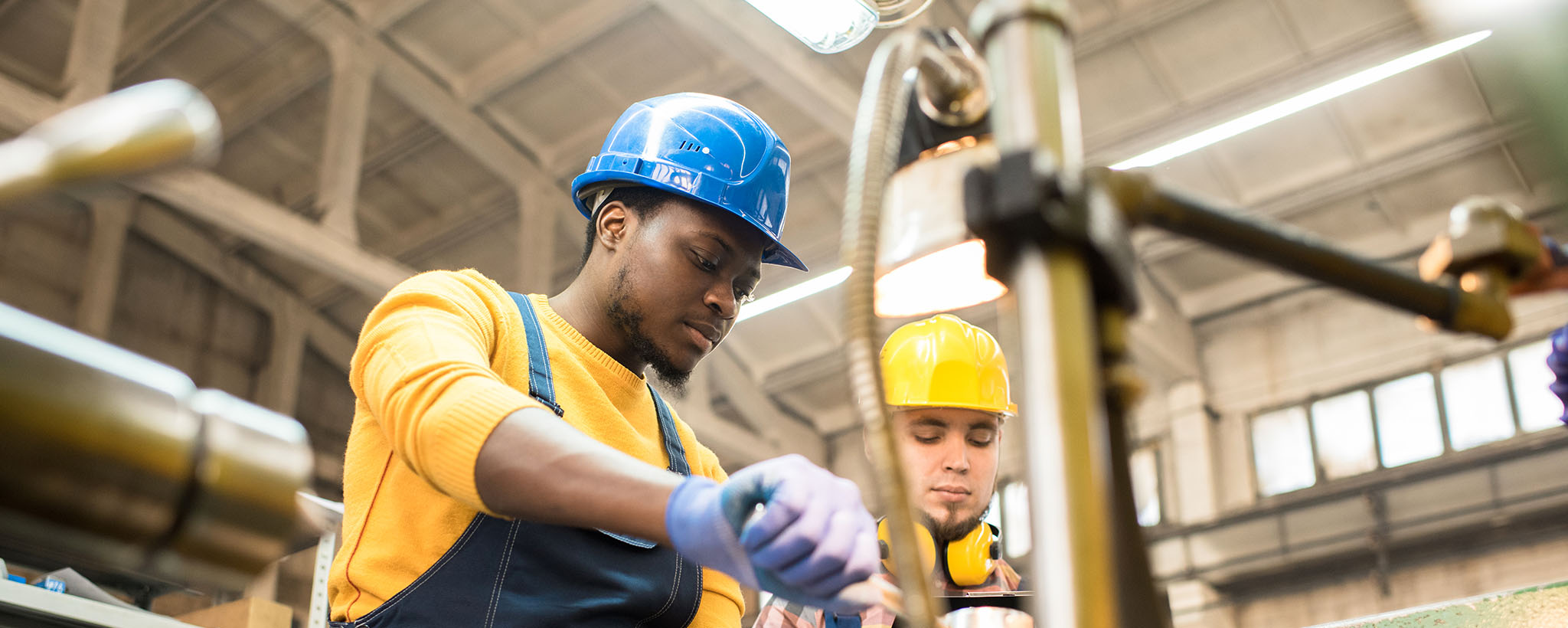 two workers wearing hardhats in a factory