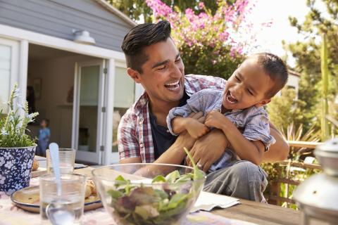 Hispanic father and son at a table. 