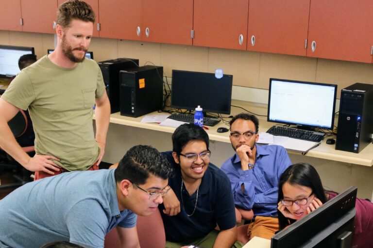 A group of SCEC interns looking at a computer