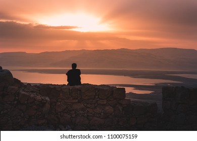 Man looking at sunrise from Masada with view on the dead sea in Israel Arkivfotografi