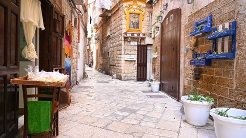 Bari, Italy, 12 of February 2022, Narrow street in the old town of Bari Vecchia.  street stand with Italian noodles, client, Catholic painting on the facade Redaksjonell arkivvideo