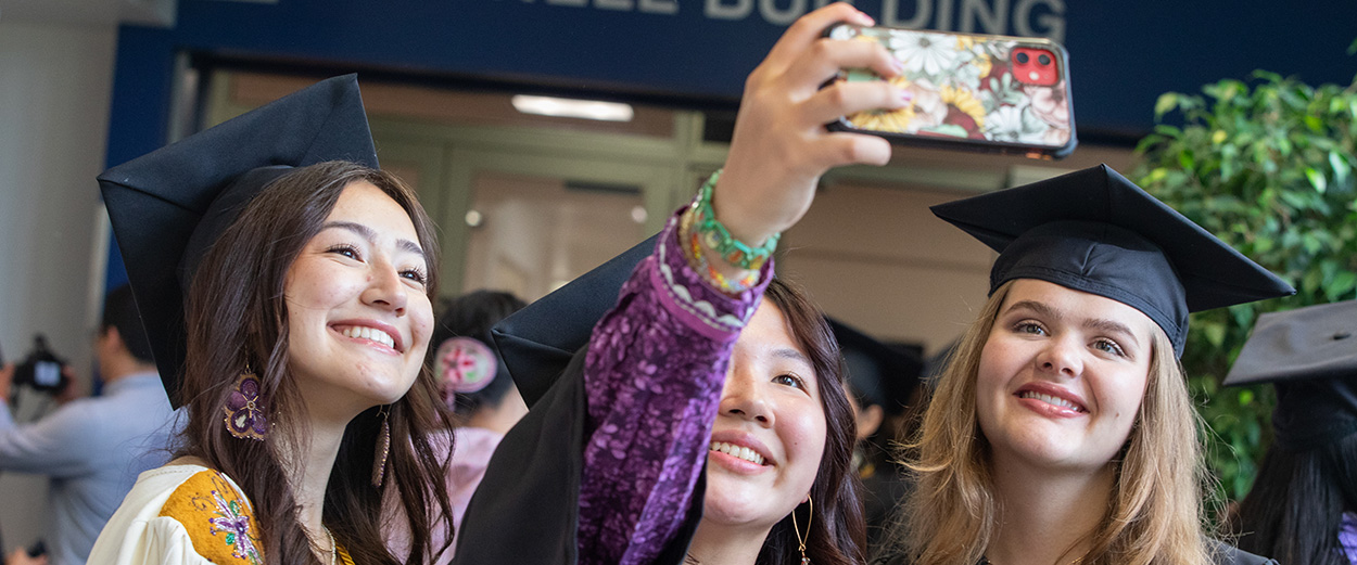 A UAF graduates pose for a selfie at the 2024 UAF Commencement Ceremony.