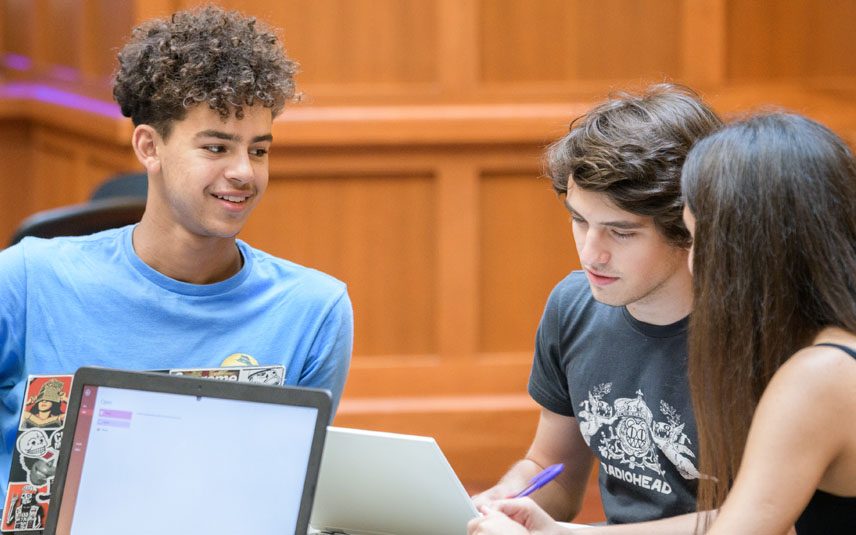 High School students doing group work around computers