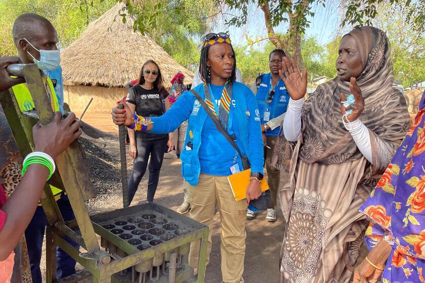 Juliette Murekeyisoni with group of women around briquette tool