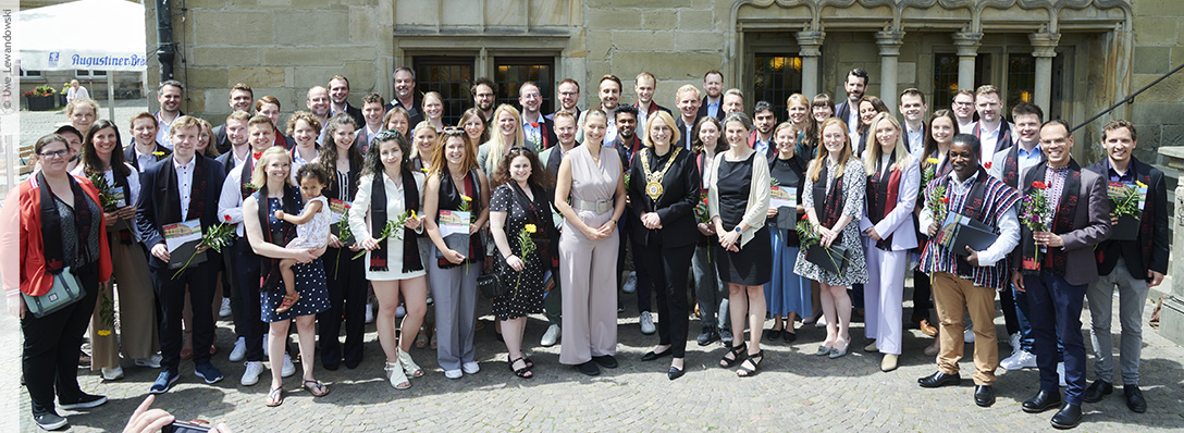 Gruppenbild mit den Doktorinnen und Doktoren, Präsidentin Susanne Menzel-Riedl und Vizepräsidentin Andrea Lenschow auf der Treppe des Rathauses