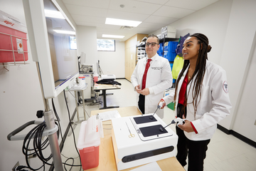 Dr. Ovunc Bardakcioglu (left), associate professor and chief of colorectal surgery, and class of 2025 medical student Jessica Fields during a robotic surgery simulation training.