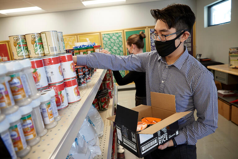 A man stocking shelfs at the food pantry