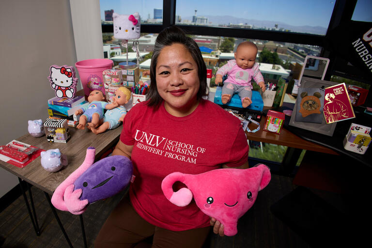 woman holding stuffed reproductive organ objects