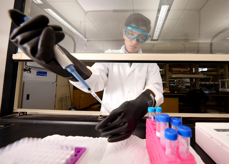 man in white coat using lab equipment