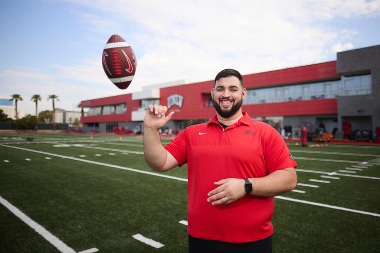 A portait of former UNLV defensive lineman, Ammir Aziz, throwing a football.