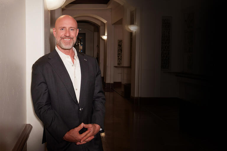 cropped photo of man in suit standing with hands clasped