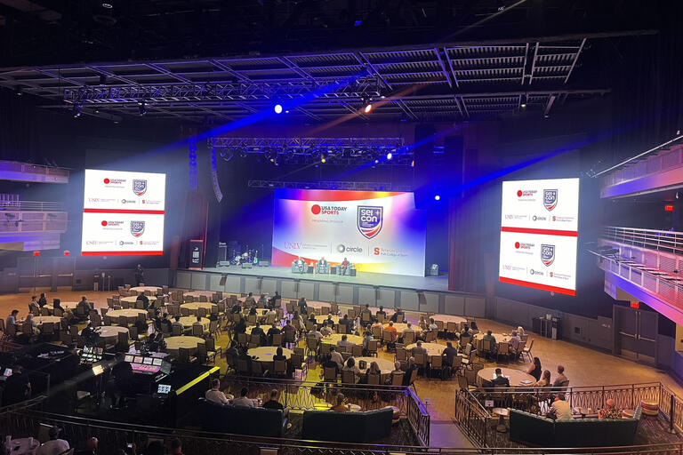 overview of conference venue with panel speakers on stage