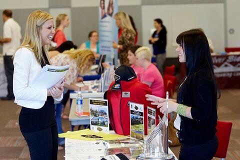 Two people talking at a career fair