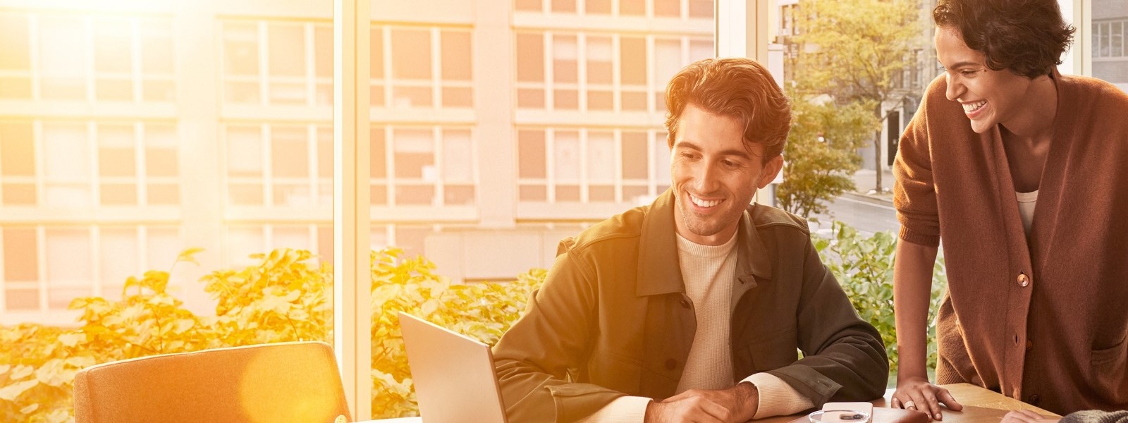 Coworkers joyfully working on laptop