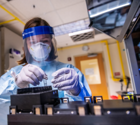 Researcher working in lab wearing protective gear 