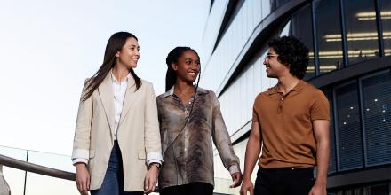 Three postgraduate students walking together on campus