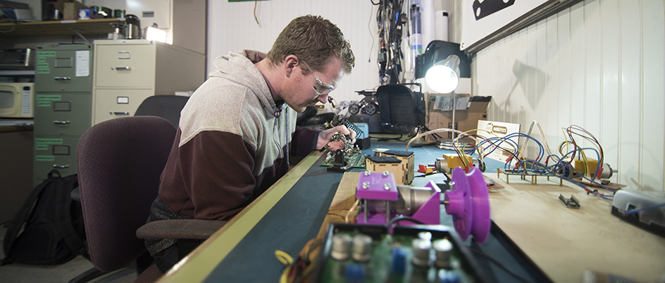 UVic student Matthew McCann working with electrical components in a robotics lab