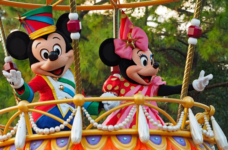 A image of Mickey Mouse and Minnie Mouse in colorful outfits on a parade float.