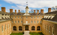 Aerial view of the historic brick Wren Building against a blue sky with light clouds