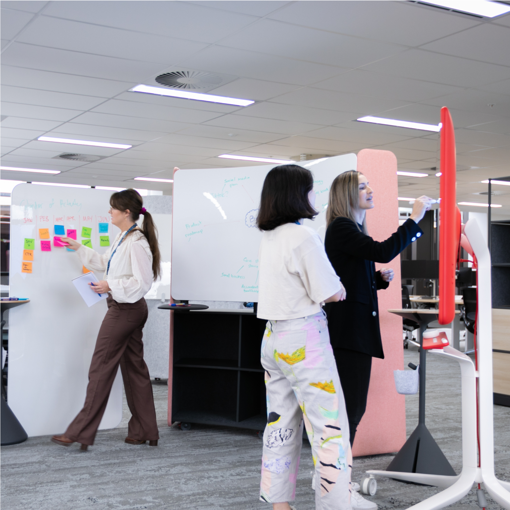 Two people outlining project plans on a whiteboard.