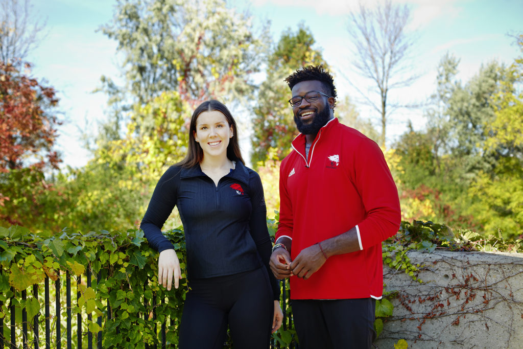 Male and female student standing outside.