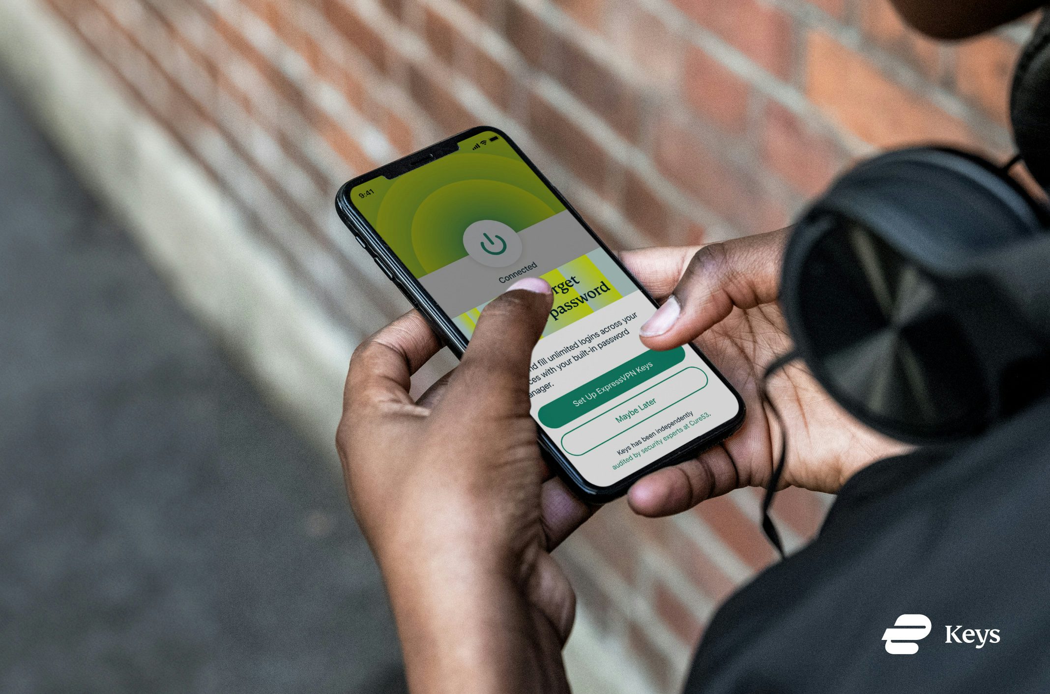 Someone holding a phone showing the ExpressVPN Keys UI.
