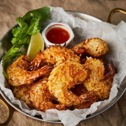 Crispy Coconut Shrimp Served with Sweet and Spicy Dipping Sauce, Garnished with Lime and Cilantro - Delicious Seafood Appetizer