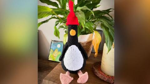 A crocheted Feathers McGraw from Wallace and Gromit sat on a shelf.