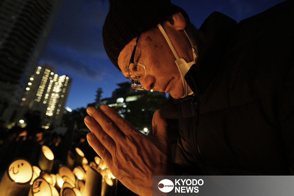 阪神大震災の追悼会場で手を合わせる男性＝２０２５年１月１７日午後５時４６分、神戸市中央区の東遊園地（共同）