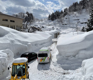 新潟・長野県境の秋山郷の結東地区。一帯は車の高さを超える厚い雪で覆われている=2025年2月23日、新潟県津南町結東、茂木克信撮影